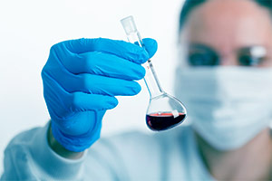 decorative image of researcher looking at a vial of liquid